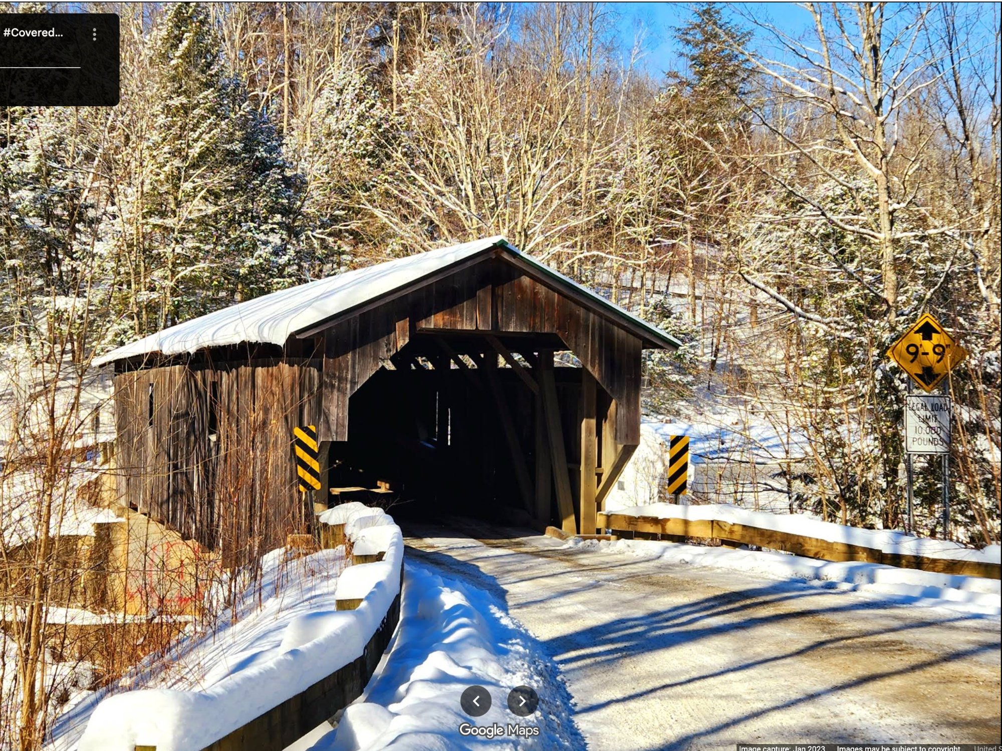 Historic Grist Mill Covered Bridge in winter with snow-covered surroundings